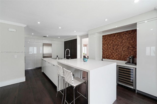 kitchen with modern cabinets, beverage cooler, white cabinets, light countertops, and recessed lighting