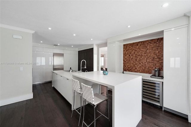 kitchen featuring modern cabinets, wine cooler, white cabinetry, light countertops, and dark wood finished floors