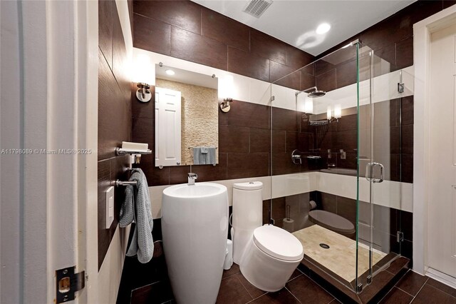 7567 SW 189th St, Cutler Bay, FL 33157 - full bathroom featuring a stall shower, toilet, tile patterned flooring, and tile walls