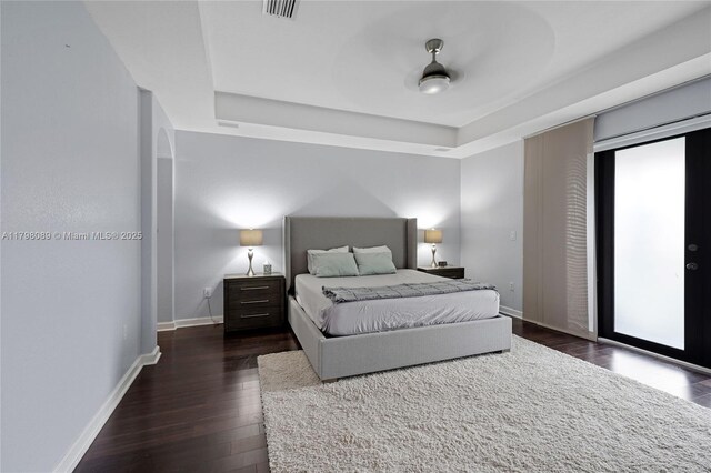 7567 SW 189th St, Cutler Bay, FL 33157 - bedroom featuring wood finished floors, a tray ceiling, baseboards, and access to exterior