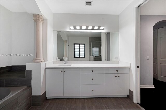 7567 SW 189th St, Cutler Bay, FL 33157 - full bathroom with decorative columns, a stall shower, a garden tub, vanity, and wood finished floors