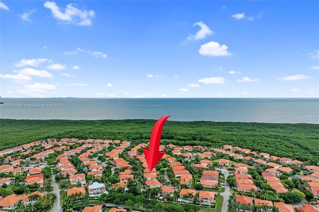 aerial view of property and surrounding area featuring a large body of water and nearby suburban area