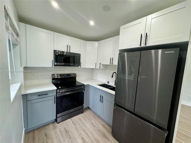 2631 SW 13th Ave, Fort Lauderdale, FL 33315 - kitchen featuring freestanding refrigerator, electric stove, a sink, light wood-style flooring, and light countertops