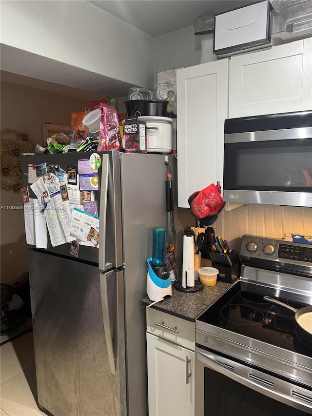 2631 SW 13th Ave, Fort Lauderdale, FL 33315 - kitchen with appliances with stainless steel finishes, light tile patterned floors, white cabinets, and dark countertops