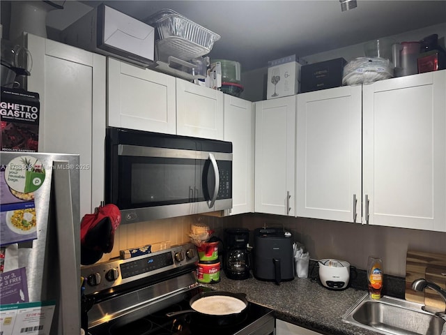 2631 SW 13th Ave, Fort Lauderdale, FL 33315 - kitchen featuring stainless steel appliances, a sink, and white cabinets