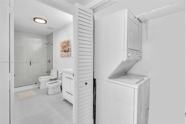 2650 SW 37th Ave Unit 906, Miami, FL 33133 - washroom with stacked washer and clothes dryer and light tile patterned floors