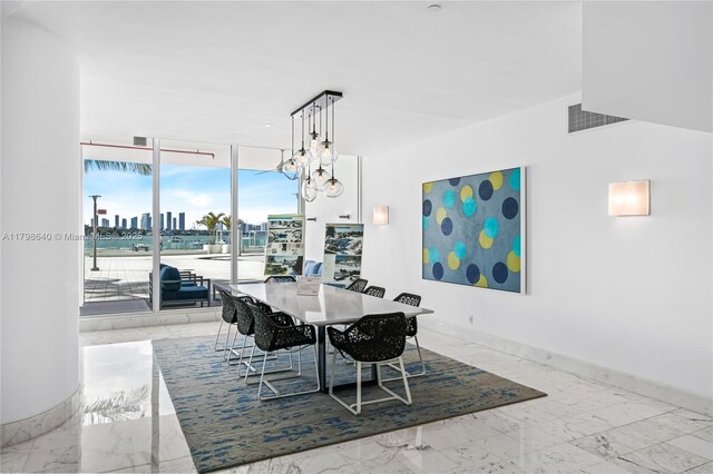1000 W Ave Unit 308, Miami Beach, FL 33139 - dining room featuring marble tiled flooring, floor to ceiling windows, baseboards, and a chandelier