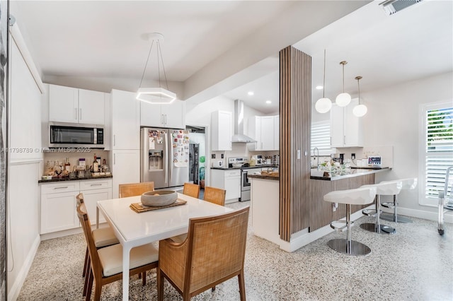 dining room with dark aggregate flooring, baseboards, and recessed lighting