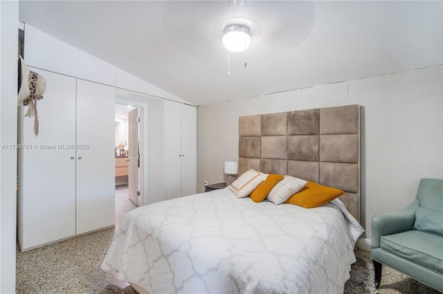 bedroom featuring vaulted ceiling, connected bathroom, and dark speckled floor
