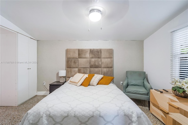 bedroom with a closet, ceiling fan, and baseboards