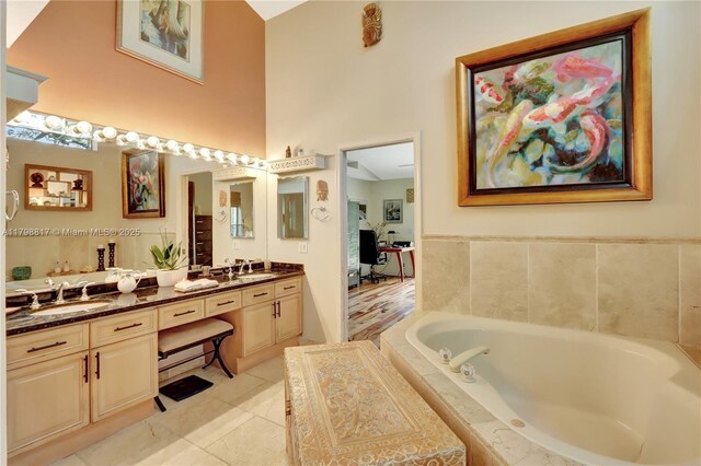 95 E Westwood Cir E, West Palm Beach, FL 33411 - full bath with double vanity, a bath, a high ceiling, and tile patterned floors