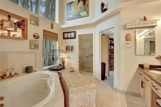 95 E Westwood Cir E, West Palm Beach, FL 33411 - full bath featuring vanity, a whirlpool tub, tiled shower, a towering ceiling, and baseboards