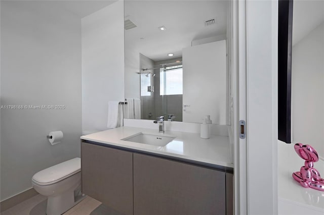 bathroom with toilet, a shower stall, and vanity