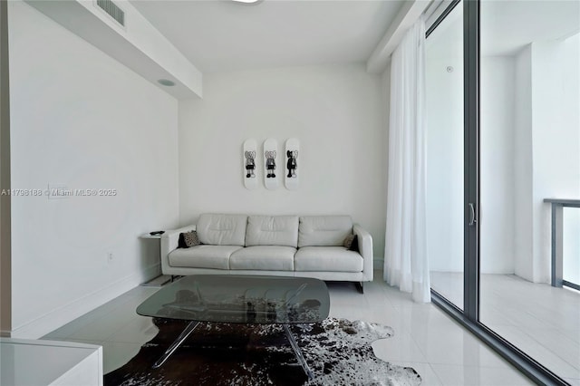 living area featuring tile patterned floors and baseboards