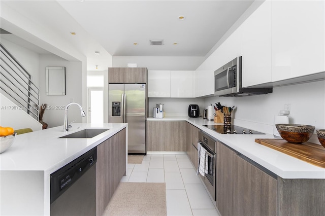 2475 NE 135th St, North Miami, FL 33181 - kitchen featuring appliances with stainless steel finishes, a sink, modern cabinets, light countertops, and white cabinetry