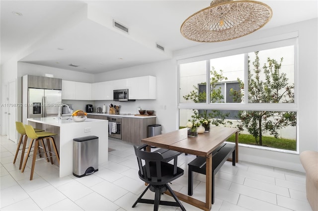 2475 NE 135th St, North Miami, FL 33181 - dining room with healthy amount of natural light and light tile patterned floors