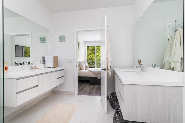 2475 NE 135th St, North Miami, FL 33181 - bathroom featuring two vanities, connected bathroom, tile patterned flooring, and baseboards