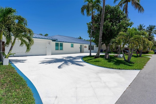 2711 NE 57th Ct, Fort Lauderdale, FL 33308 - ranch-style house with concrete driveway, a standing seam roof, a garage, metal roof, and stucco siding