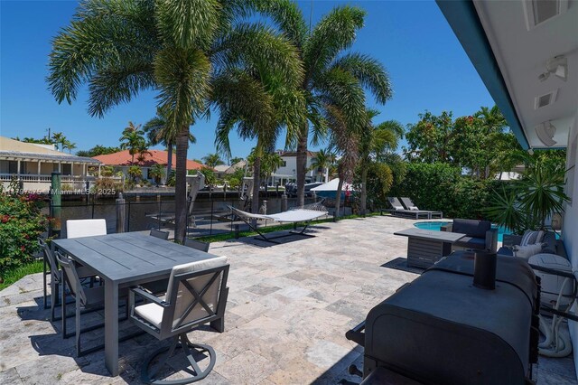 2711 NE 57th Ct, Fort Lauderdale, FL 33308 - view of patio / terrace with outdoor dining area, a water view, a boat dock, and an outdoor living space