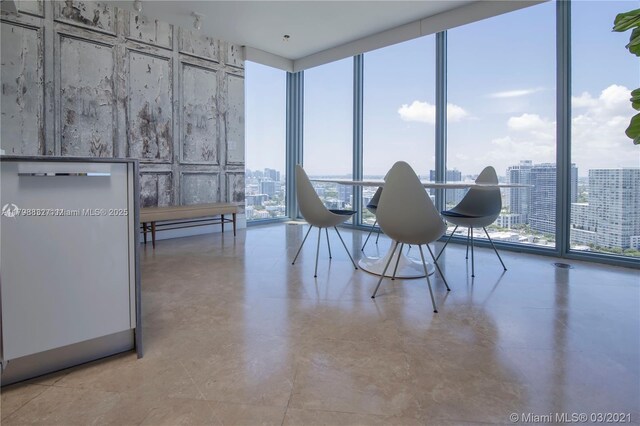 601 NE 36th St Unit 3101, Miami, FL 33137 - dining space with a wall of windows, a baseboard radiator, finished concrete flooring, and a city view