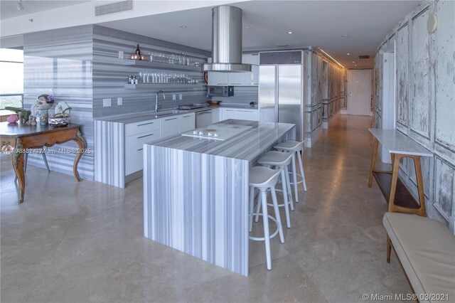 601 NE 36th St Unit 3101, Miami, FL 33137 - kitchen with island range hood, white cabinets, light countertops, appliances with stainless steel finishes, and a center island