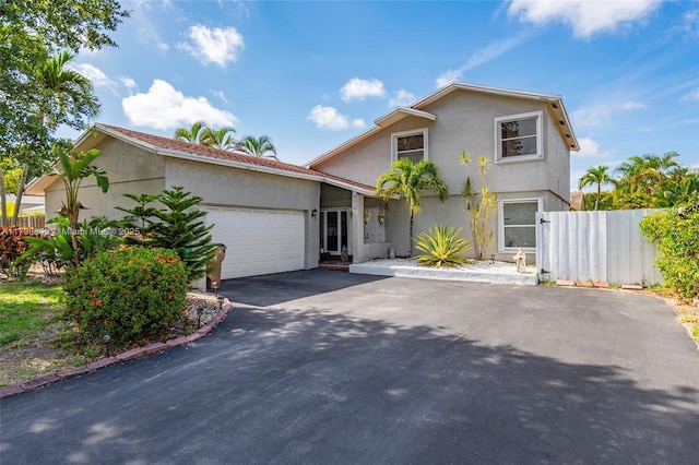 3865 NW 1st Pl, Deerfield Beach, FL 33442 - view of front facade with stucco siding, asphalt driveway, fence, and an attached garage