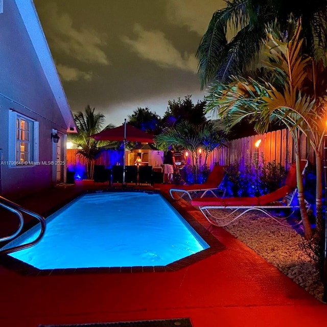3865 NW 1st Pl, Deerfield Beach, FL 33442 - pool at night with a fenced backyard and a patio area
