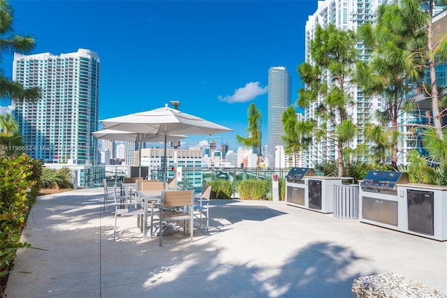 view of patio / terrace with area for grilling, a city view, and outdoor dining space