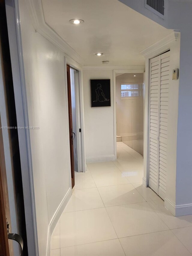 corridor featuring baseboards, light tile patterned flooring, and recessed lighting