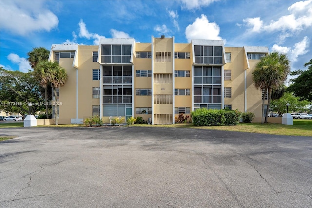 view of apartment building / complex with uncovered parking