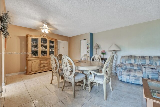 922 NE 199th St Unit 206, Miami, FL 33179 - dining area featuring ceiling fan, a textured ceiling, light tile patterned flooring, and baseboards