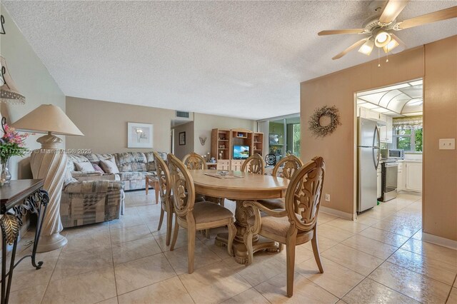 922 NE 199th St Unit 206, Miami, FL 33179 - dining space with a textured ceiling, ceiling fan, light tile patterned floors, and baseboards