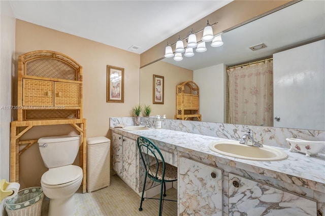 full bath featuring toilet, tile patterned floors, and double vanity