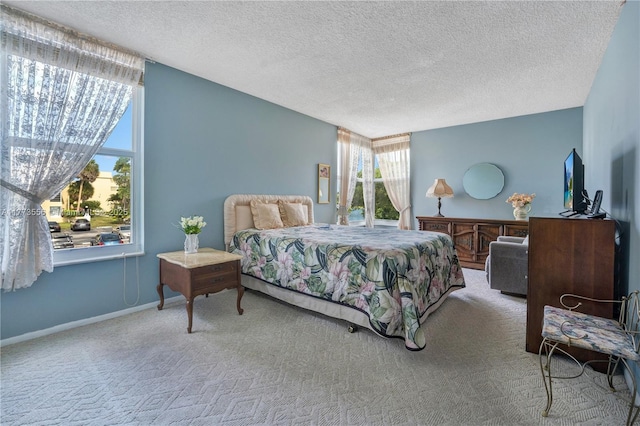 carpeted bedroom featuring multiple windows, a textured ceiling, and baseboards