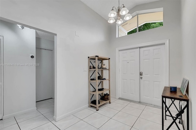 foyer entrance featuring vaulted ceiling, light tile patterned flooring, a chandelier, and baseboards