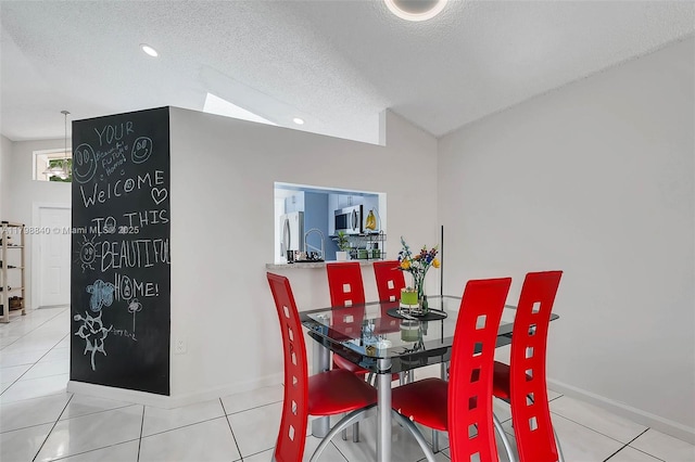 dining space with baseboards, light tile patterned flooring, and a textured ceiling