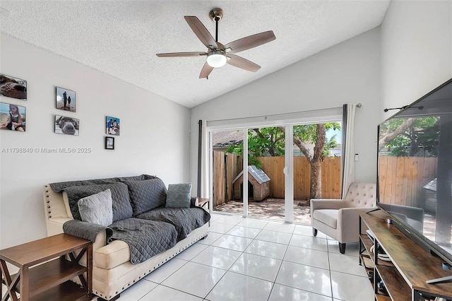 living area featuring vaulted ceiling, a ceiling fan, a textured ceiling, and light tile patterned floors