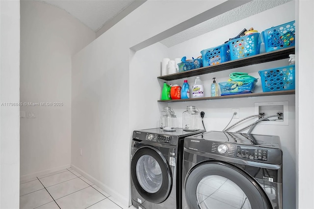 laundry room featuring washer and dryer, tile patterned flooring, and baseboards