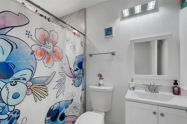 bathroom featuring toilet, vanity, and a shower with curtain