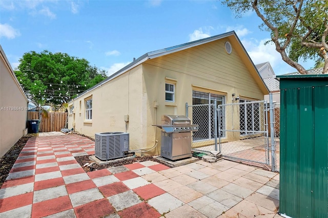 back of property featuring a gate, central AC, a patio, and fence