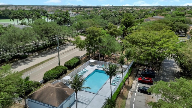 bird's eye view of a pool and a tree filled landscape