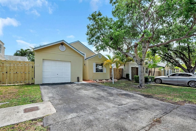 single story home with stucco siding, concrete driveway, a garage, and fence