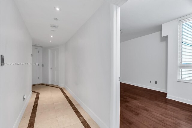 corridor with recessed lighting, healthy amount of natural light, and baseboards