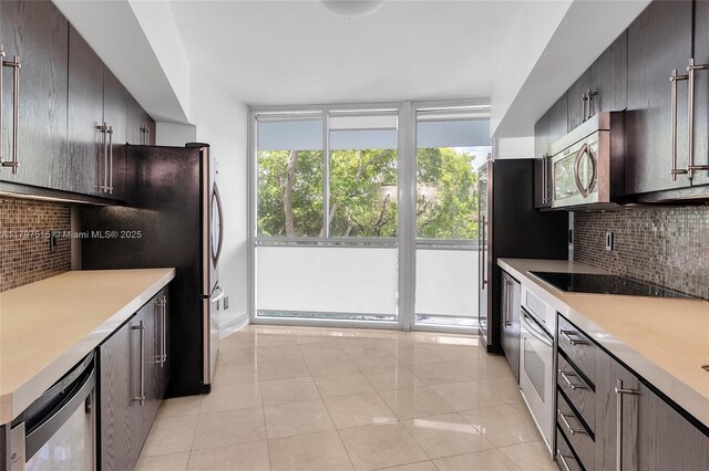 kitchen with stainless steel appliances, backsplash, light countertops, and light tile patterned floors