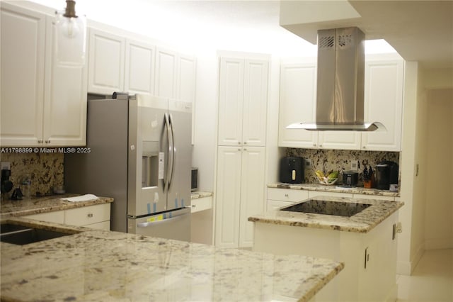 kitchen featuring stainless steel fridge, backsplash, black electric cooktop, and island exhaust hood