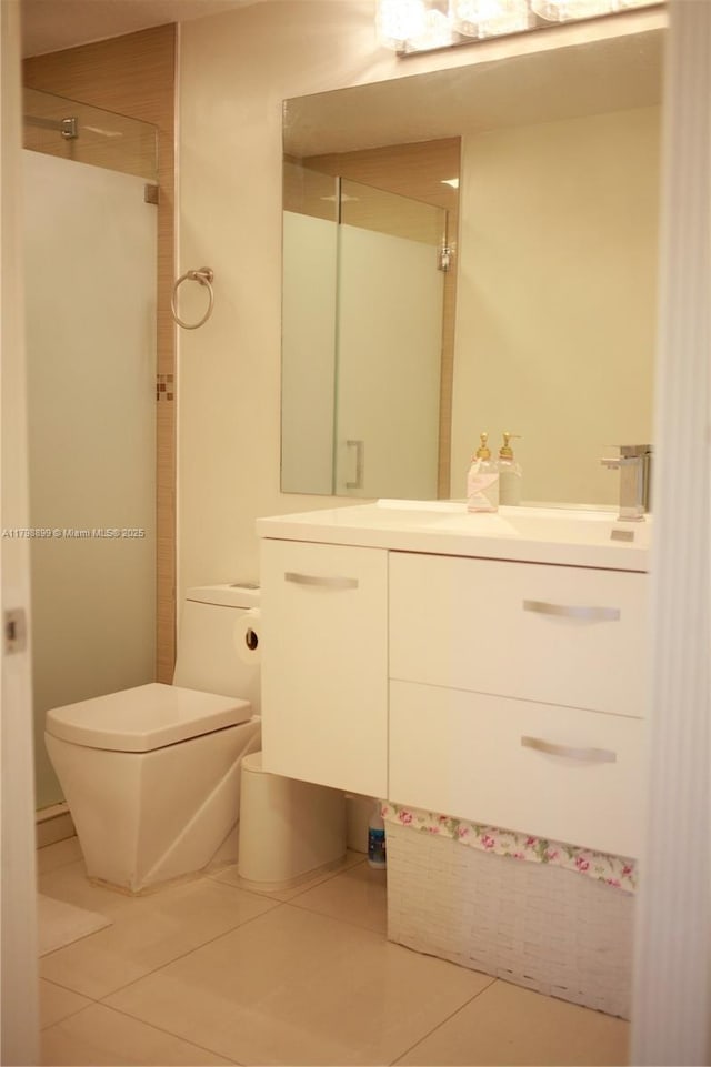 bathroom with tile patterned floors, a shower stall, toilet, and vanity