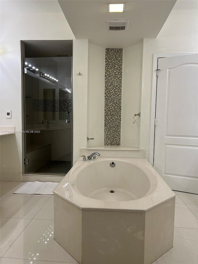 bathroom featuring tile patterned floors, a garden tub, and a shower stall