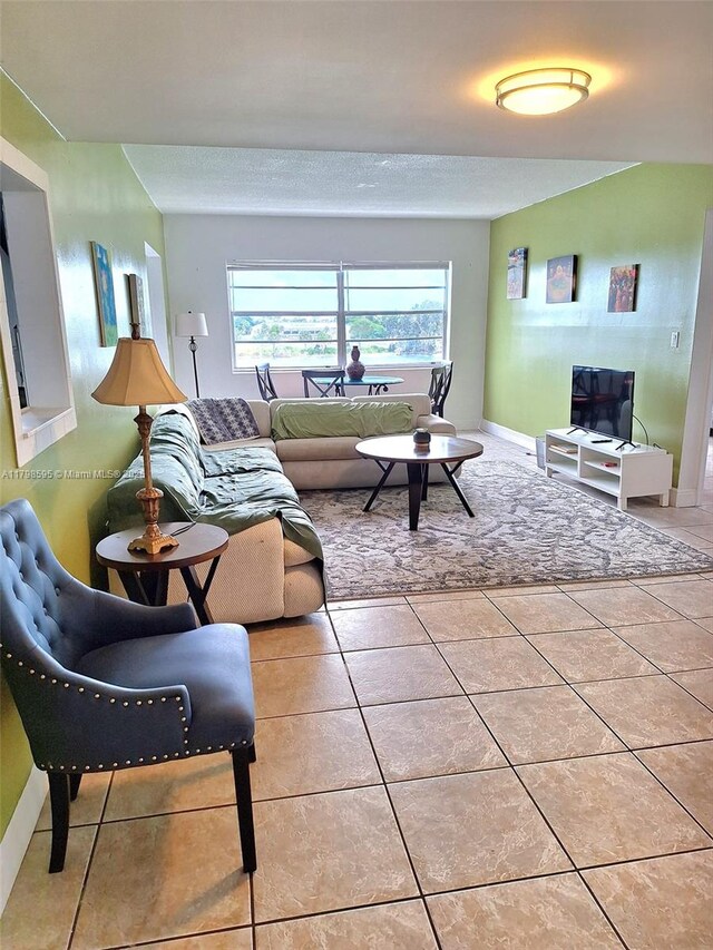 living area featuring light tile patterned flooring and baseboards