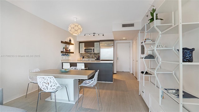 55 SE 6th St Unit 1804, Miami, FL 33131 - dining space featuring light wood-style flooring, track lighting, and baseboards