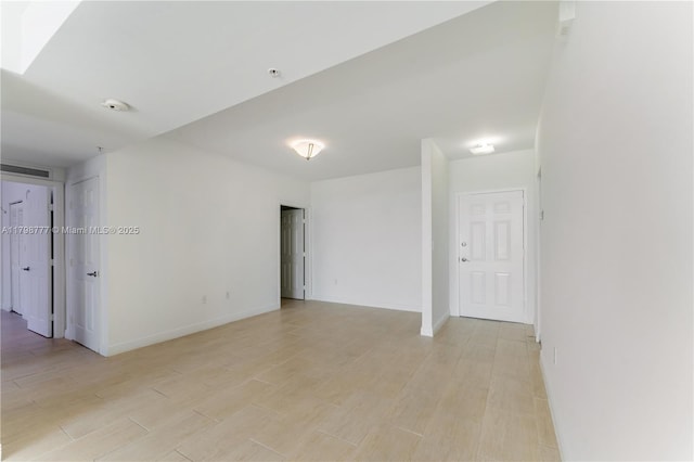 2425 SW 27th Ave Unit 1408, Miami, FL 33145 - empty room with light wood finished floors, a smoke detector, and baseboards